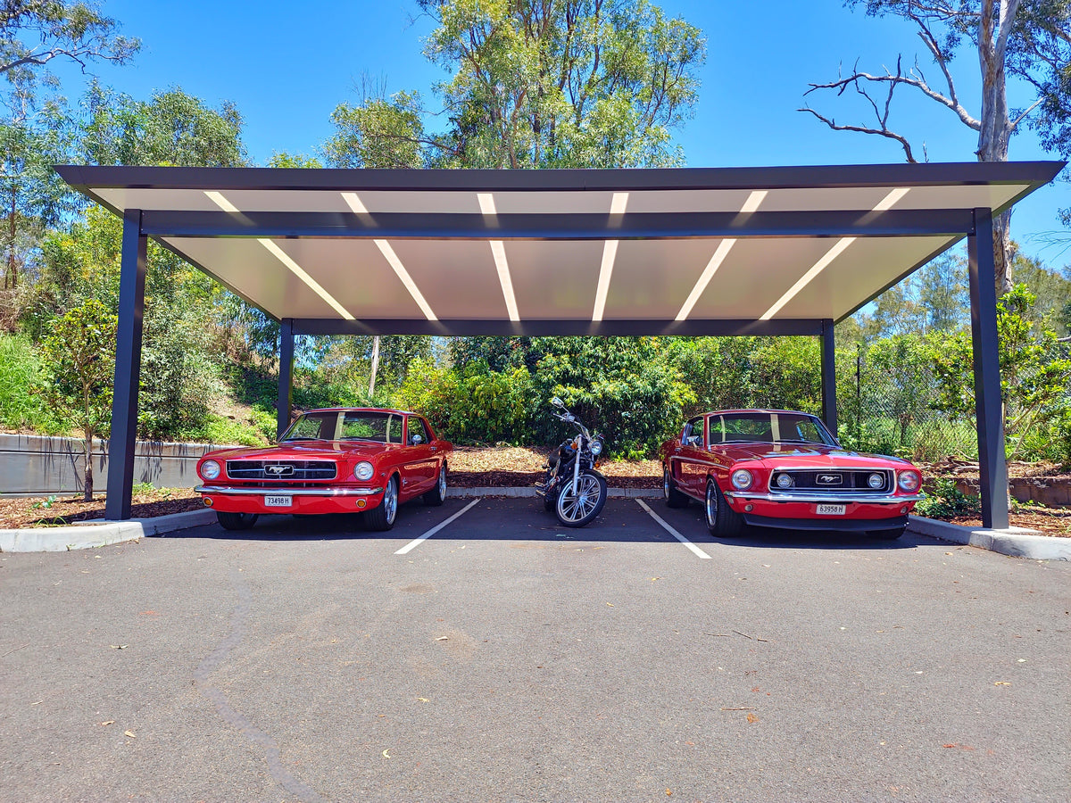 Freestanding patio carport sheltering two classic cars and a motorcycle